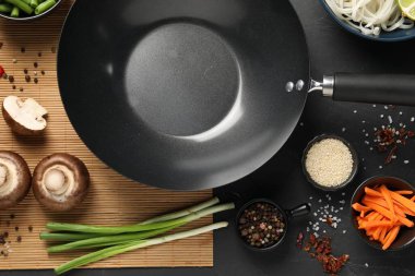 Siyah tava, baharat ve ürünlerle koyu masa üzerinde düz kompozisyon