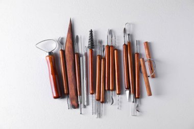 Beyaz desenli masa üzerinde farklı kil işleme araçları seti, düz yatıyordu