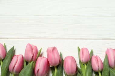 Anneler Günün kutlu olsun. Beyaz ahşap masadaki güzel pembe laleler, düz yatıyordu. Metin için boşluk