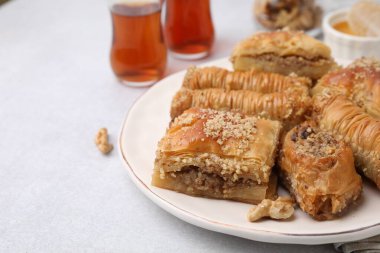 Doğu tatlıları. Lezzetli baklava parçaları beyaz masada, yakın plan. Metin için boşluk