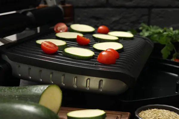 Electric grill with vegetables on table, closeup