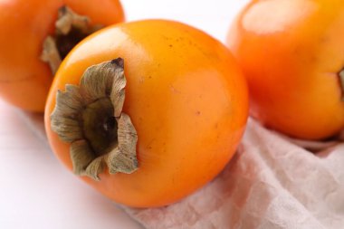 Lezzetli olgun hurmalar beyaz masada, yakın plan