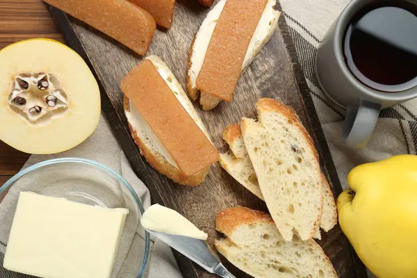 Lezzetli bıldırcın ezmesi, ekmek, tereyağı, bir fincan çay ve ahşap masada taze meyveler.
