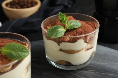 Lezzetli tiramisu bardaklar ve nane yaprakları, masa, yakın çekim