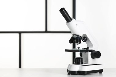 Beyaz tabloda modern mikroskop, metin için boşluk