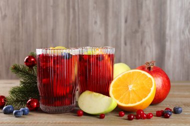 Bardaklarda, malzemelerde ve Noel dekorunda ahşap masada Aromatik Sangria içeceği.