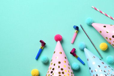 Parti şapkaları ve turkuaz arka planda diğer parlak dekorlar, düz yatış. Metin için boşluk