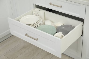 Temiz tabaklar, fincanlar ve kase kapalı çekmecede.