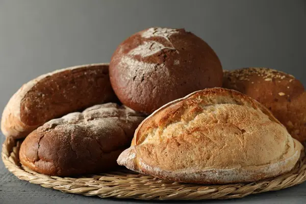 Wicker Basket Different Types Fresh Bread Grey Table Closeup — Stock Photo, Image