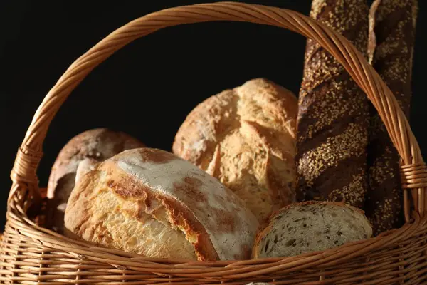 Wicker Basket Different Types Fresh Bread Black Background — Stock Photo, Image