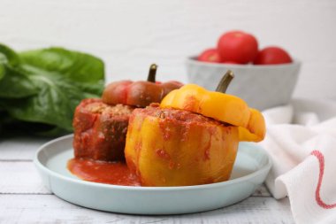 Doldurulmuş dolma biberler beyaz ahşap masada.