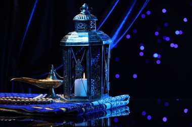 Arap feneri, Misbaha, Aladdin sihirli lamba ve gece bulanık ışıklara karşı ayna yüzeyinde katlanmış seccade. Metin için boşluk