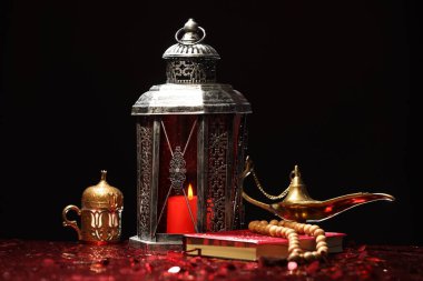 Arapça fener, Kuran, Misbaha ve Aladdin sihirli lamba parlak kırmızı masada.