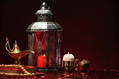 Arap feneri, Kuran, Misbaha, yanan mum ve parlak kırmızı masada Aladdin sihirli lamba. Metin için boşluk