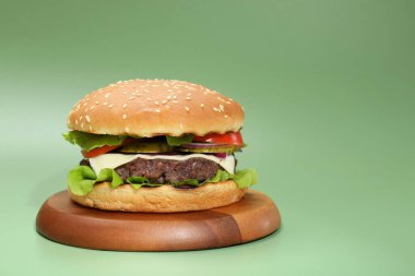 Yeşil arka planda lezzetli köfteli burger. Metin için boşluk