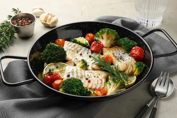 Tasty cod cooked with vegetables served on grey table