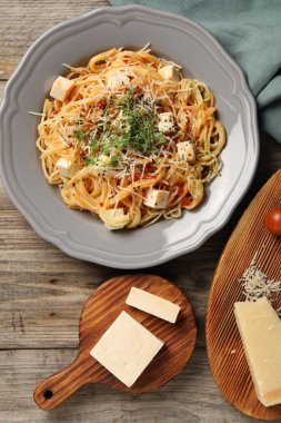 Vejetaryen yemeği. Taze mikroyeşillikli lezzetli makarna ve ahşap masada peynir, düz uzanmış.
