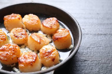 Koyu gri desenli masada lezzetli deniz tarakları, yakın plan.