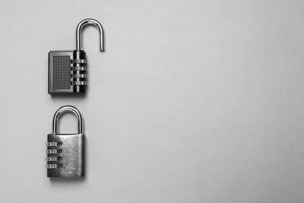 Steel combination padlocks on grey background, top view. Space for text
