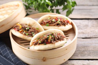Tahta masadaki bambu buharlı lezzetli gua bao.