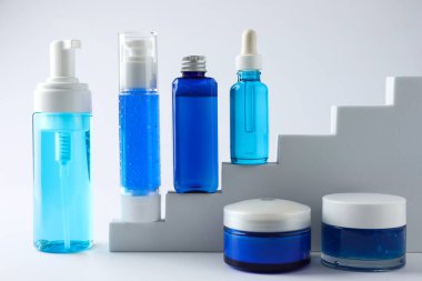 Merdivenlerde beyaz arka planda lüks kozmetik ürünleri serisi