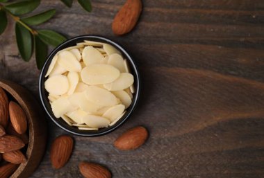 Taze badem gevrekleri kasede ve fındıklar ahşap masada, düz yerde. Metin için boşluk