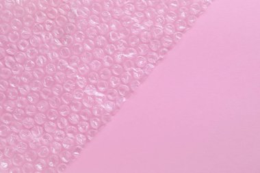Pembe arka planda şeffaf baloncuk ambalajı, üst manzara. Metin için boşluk