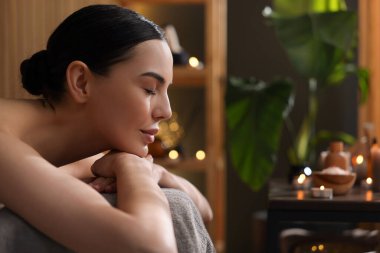 Spa terapisi. Salondaki masaj masasında uzanan güzel genç bir kadın. Mesaj için yer var.