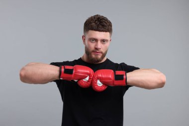 Gri arka planda boks eldivenli adam.