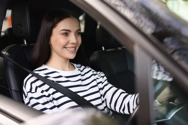 Woman with safety seat belt driving her modern car