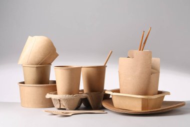 Çevre dostu gıda ambalajı. Işık arkaplanındaki kağıt kapları ve sofra takımı