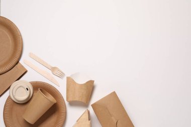 Çevre dostu gıda ambalajı. Kağıt kaplar ve masa takımı beyaz arka planda, düz yerde. Metin için boşluk