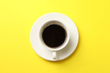 Sarı arka planda bir fincan aromatik kahve.