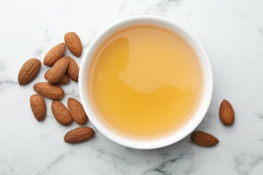 Kâsede badem yağı, beyaz mermer masada fındık, düz yatıyordu.