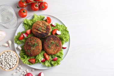 Beyaz ahşap masada servis edilen nefis vejetaryen pirzolalar. Metin için boşluk