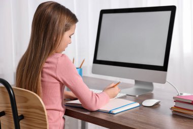 E-öğrenme. İçerideki masada online ders sırasında not alan tatlı kız.