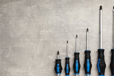 Gri masadaki tornavida seti, üst görüntü. Metin için boşluk