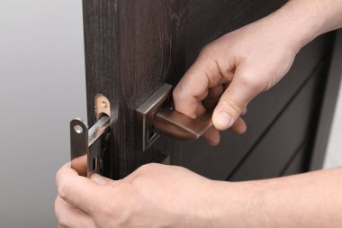 Tamirci kapı kolunu içeride değiştiriyor, yakın çekim görüntüsü var.