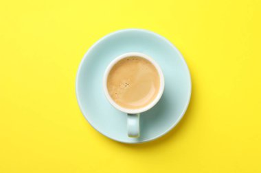 Sarı arka planda, fincanda Aromatik kahve, üst manzara.