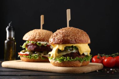Siyah ahşap masada lezzetli köfteli vejetaryen hamburgerler.