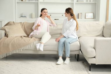 Doula evdeki kanepede hamile bir kadınla çalışıyor. Çocuk doğumu hazırlığı