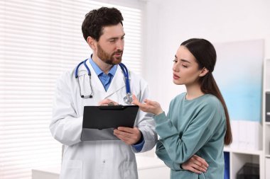 Klinikteki randevusu sırasında pano danışmanı olan bir doktor.