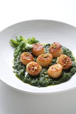 Lezzetli soslu leziz kızarmış deniz tarakları ve beyaz masada mısır salatası.