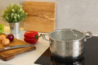 Yemek pişiriyorum. Mutfaktaki tezgahın üstünde taze sebze ve çömlek.