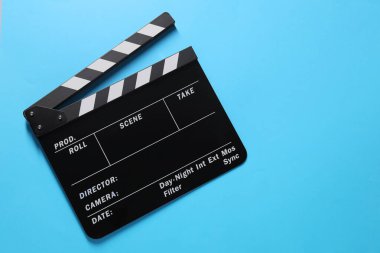 Açık mavi arka planda el çırpma tahtası, üst manzara. Metin için boşluk