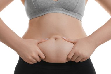 Beyaz arka planda göbek yağına dokunan kadın, yakın plan. Aşırı kilolu