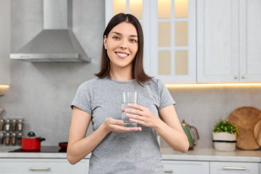 Mutfakta tatlı su bardağı ile Kadın