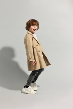 Moda konsepti. Açık gri arka planda poz veren şık çocuk.