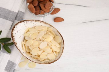 Taze badem gevrekleri ve fındıklar beyaz ahşap masada, düz yerde. Metin için boşluk