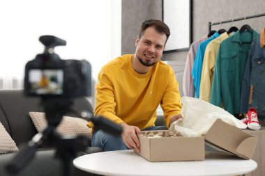 Evde paket kayıt videosuyla gülümseyen moda blogcusu